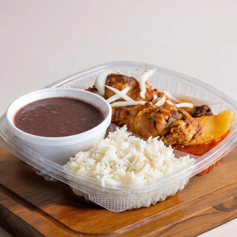 A takeout container with chicken, rice, beans, and potatoes on a wooden board.